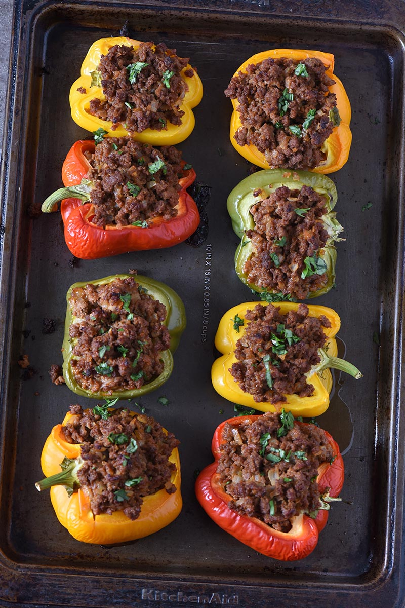 colorful sloppy joe stuffed bell peppers on a baking sheet