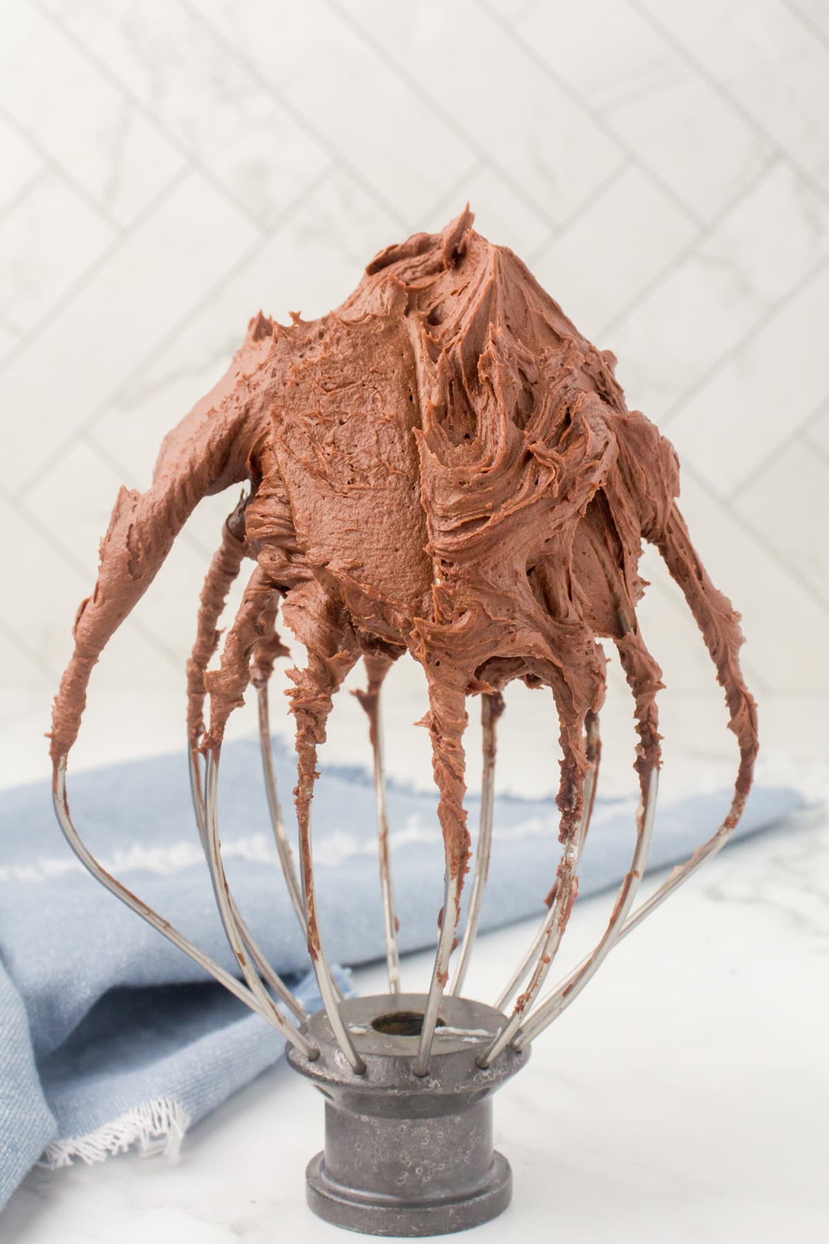 easy chocolate buttercream frosting on a whisk attachment for an electric mixer