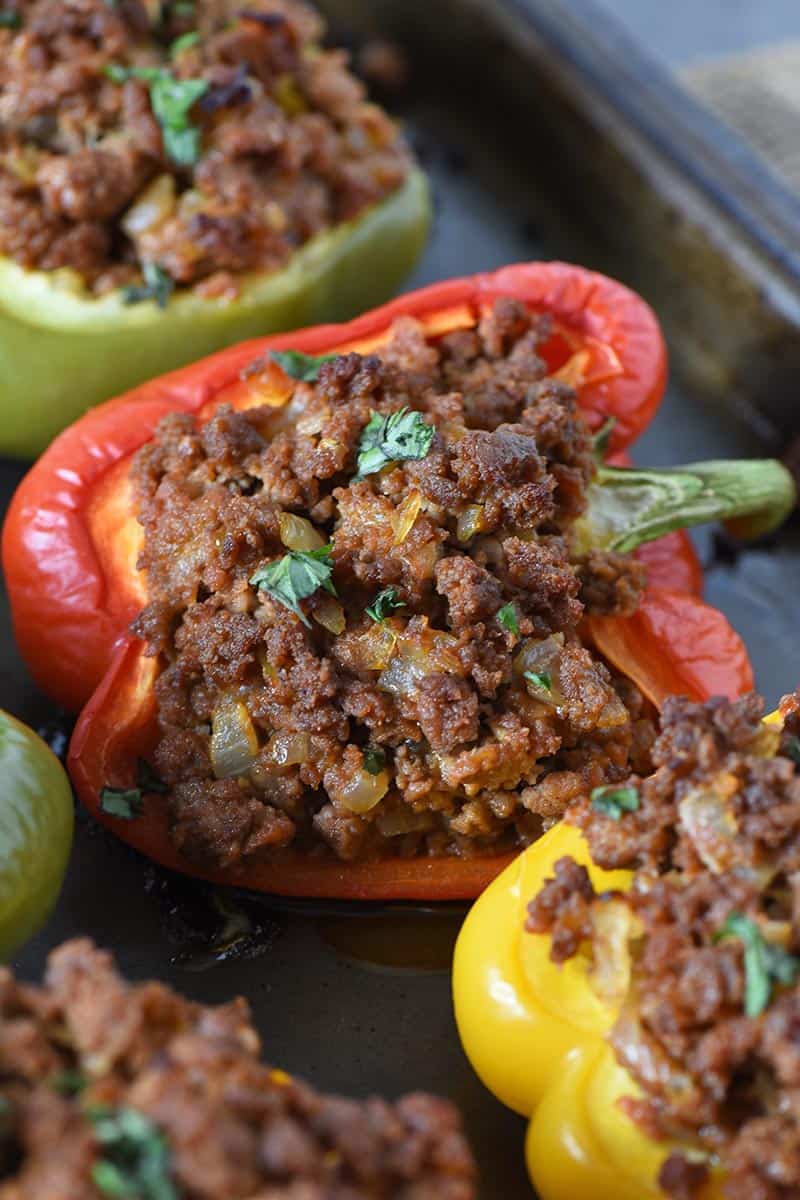 red stuffed peppers with sloppy joe meat and fresh basil on baking sheet