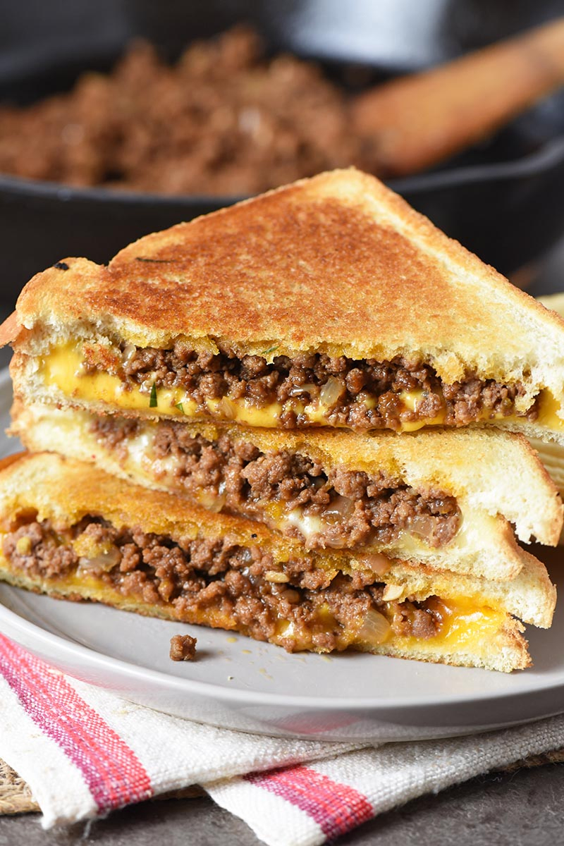 grilled cheese sloppy joes made with ground beef, sloppy joe sauce, and melted cheese, sandwiches on gray plate