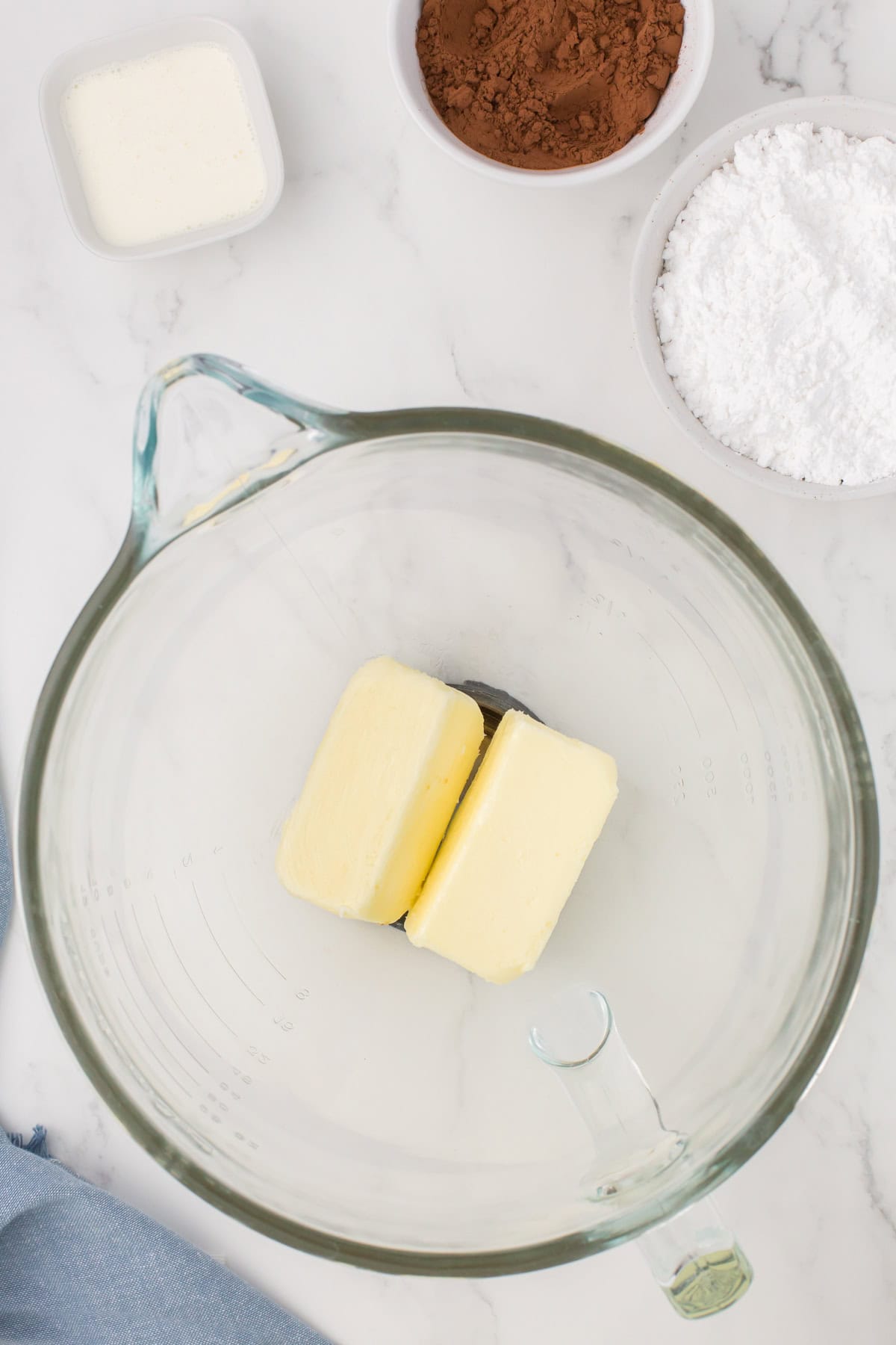 salted butter and vanilla in a large glass mixing bowl for making chocolate buttercream frosting