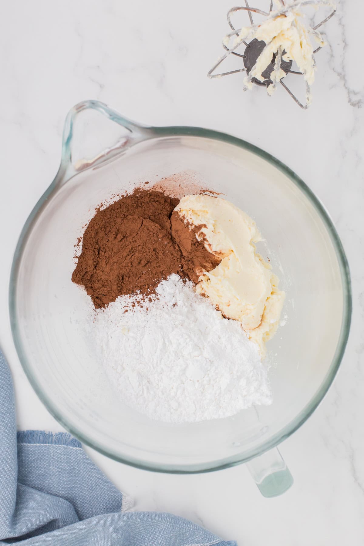 milk chocolate buttercream frosting ingredients in a large glass mixing bowl for making chocolate buttercream icing