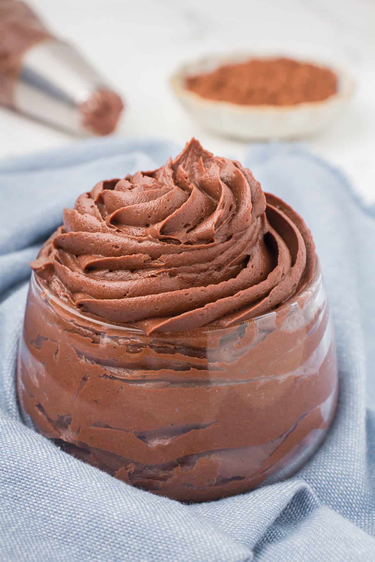 milk chocolate buttercream frosting piped into a small glass bowl