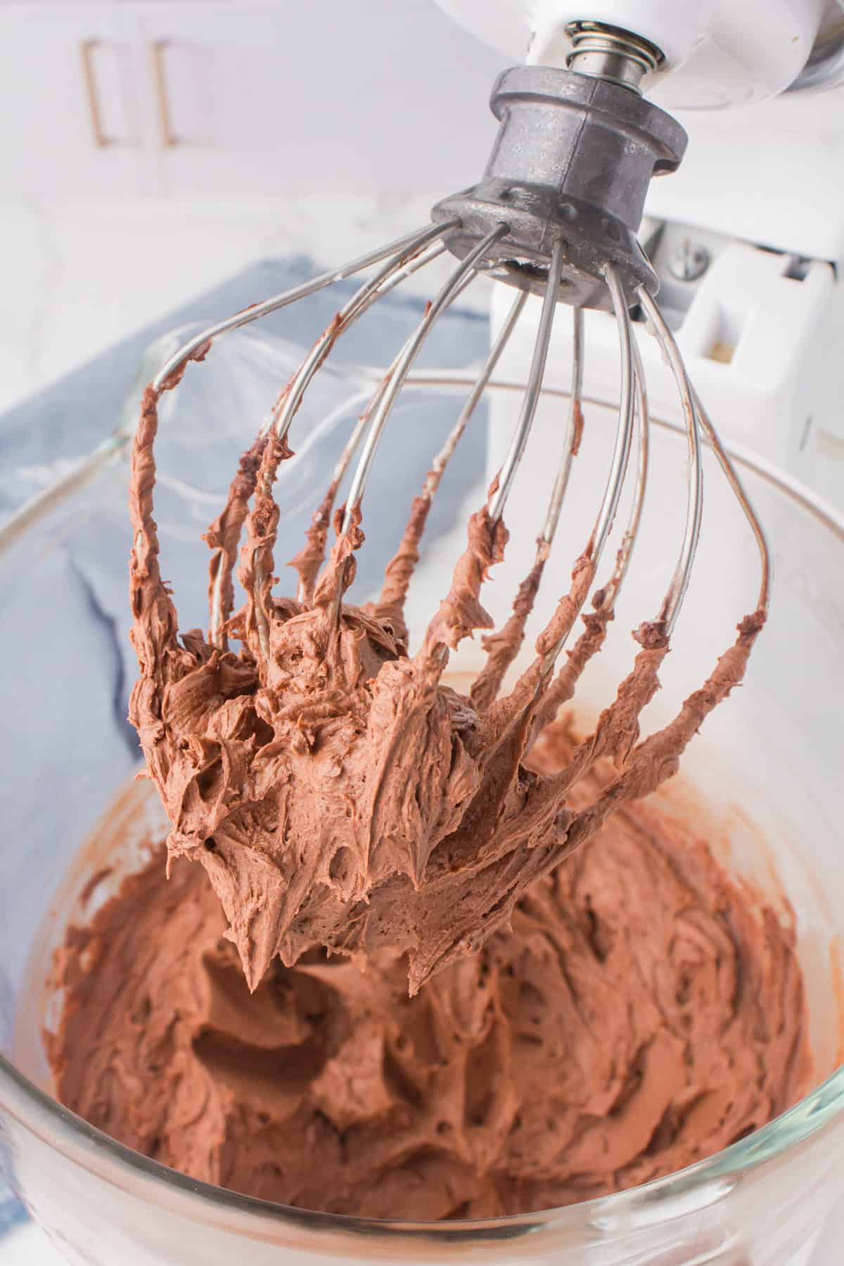 milk chocolate buttercream icing on a large whisk attachment for the electric mixer