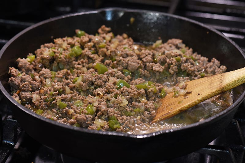 ground beef and veggie mixture for Philly cheesesteak sloppy joes, cooking in cast iron skillet