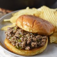 open faced Philly cheesesteak sloppy joes on toasted hamburger buns with potato chips on gray plate