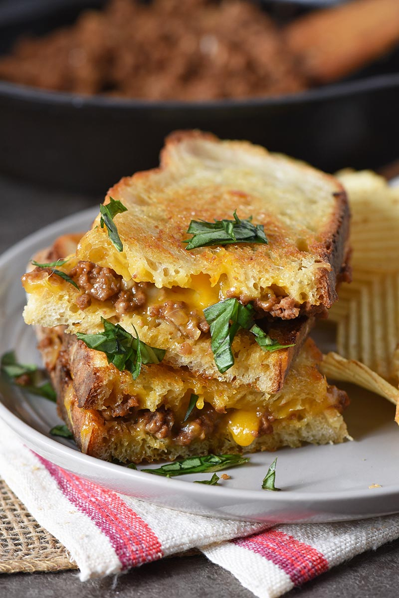 grilled cheese sloppy joes on sourdough bread on gray plate with potato chips