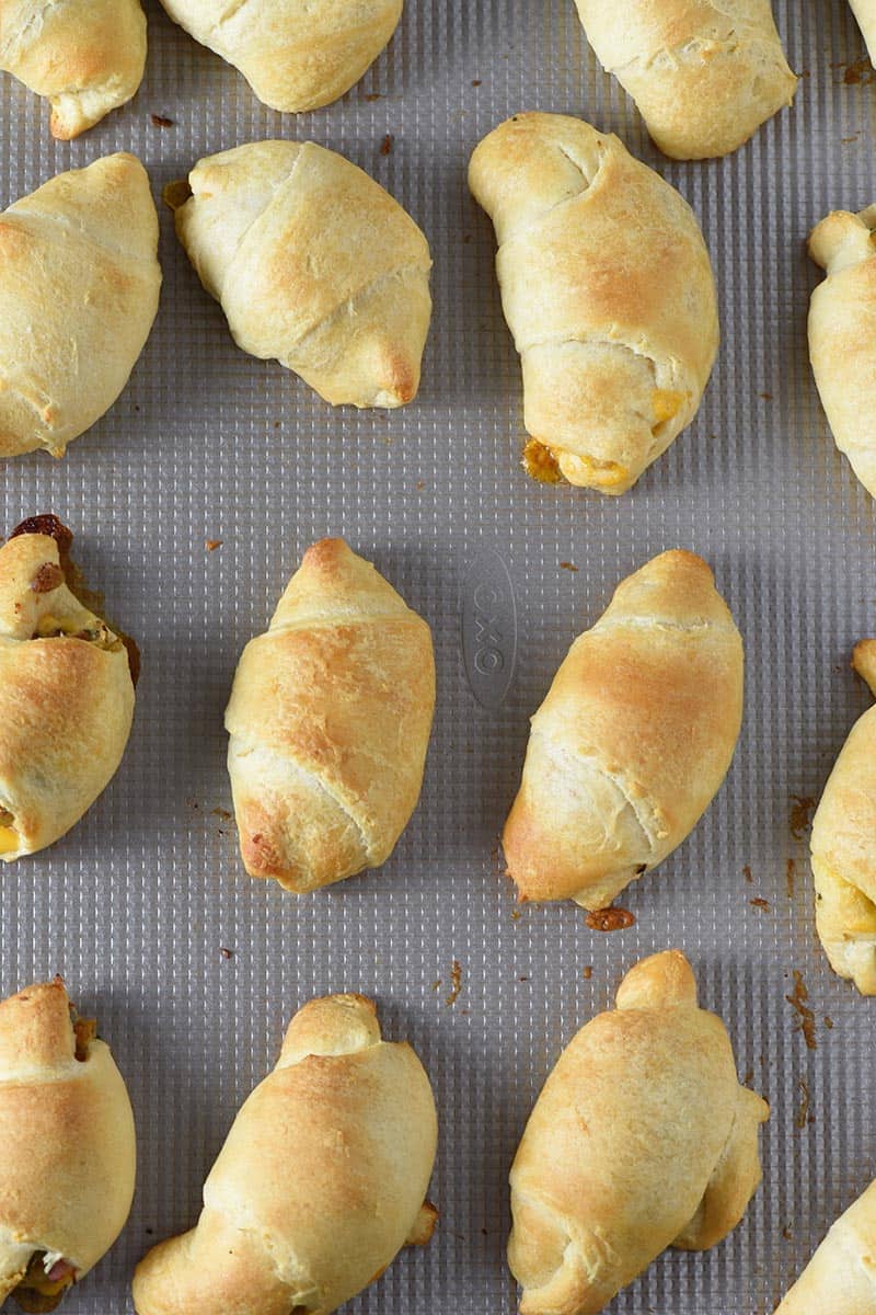 leftover ham and stuffing crescent rolls baked on a cookie sheet, ready to serve as easy appetizers