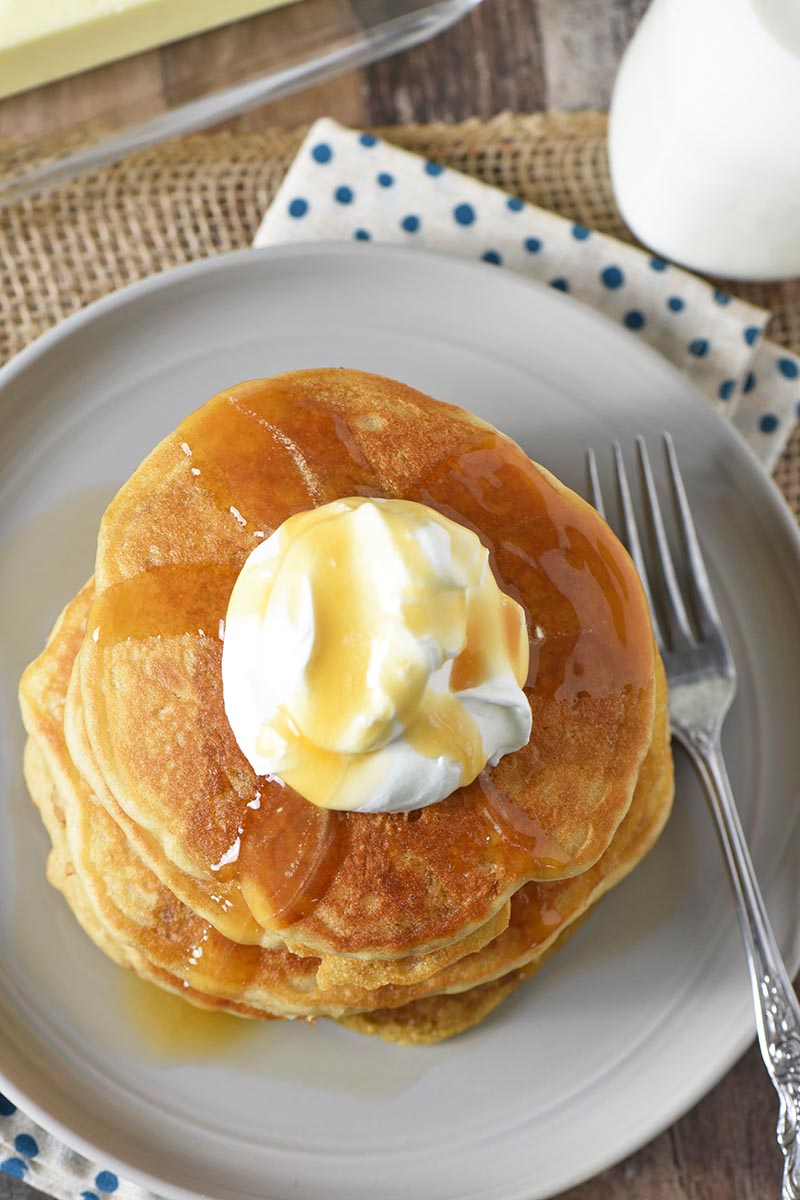 butterbeer pancakes with whipped cream and butterscotch syrup on gray plate with fork