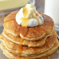 butterbeer pancakes from scratch on gray plate with whipped cream on top and butterscotch syrup