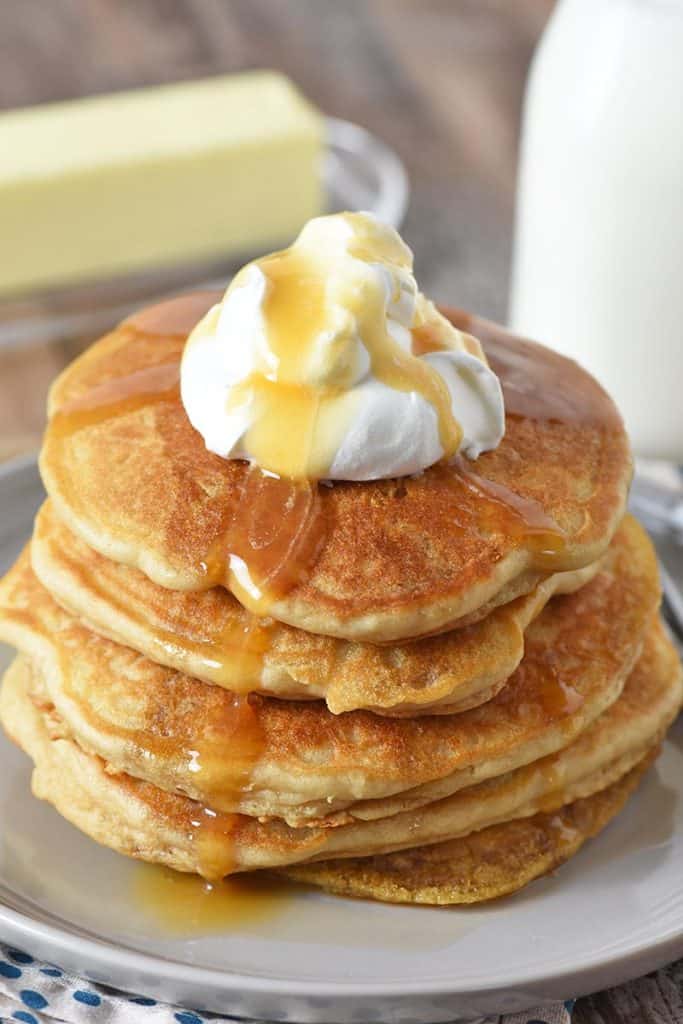 butterbeer pancakes from scratch on gray plate with whipped cream on top and butterscotch syrup