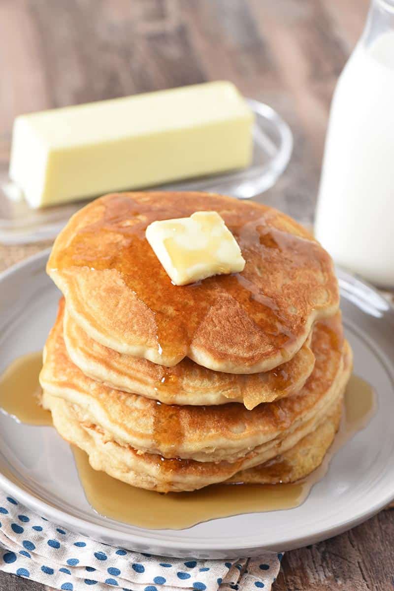 stack of butterbeer pancakes with butter and syrup on gray plate with milk