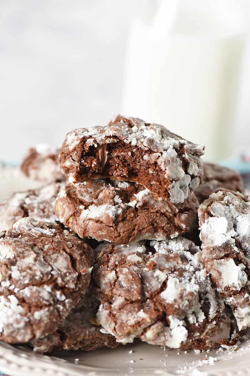 crinkles piled on plate with bite taken out of Christmas cookie, served with jar of milk