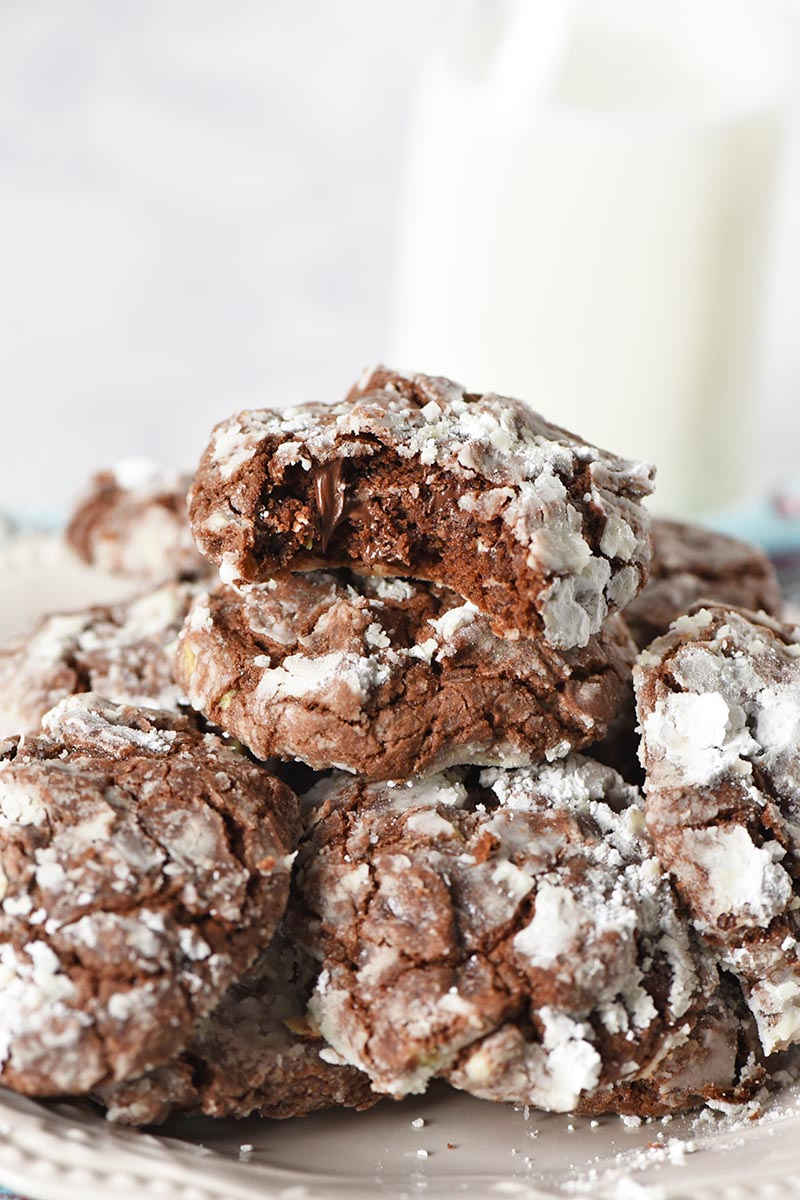 crinkles piled on plate with bite taken out of Christmas cookie, served with jar of milk