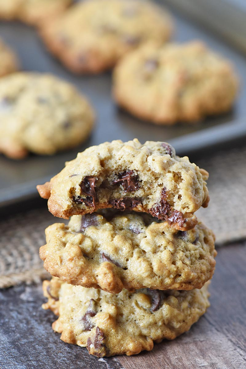 bite out of oatmeal chocolate chip cookies with stack of oatmeal cookies