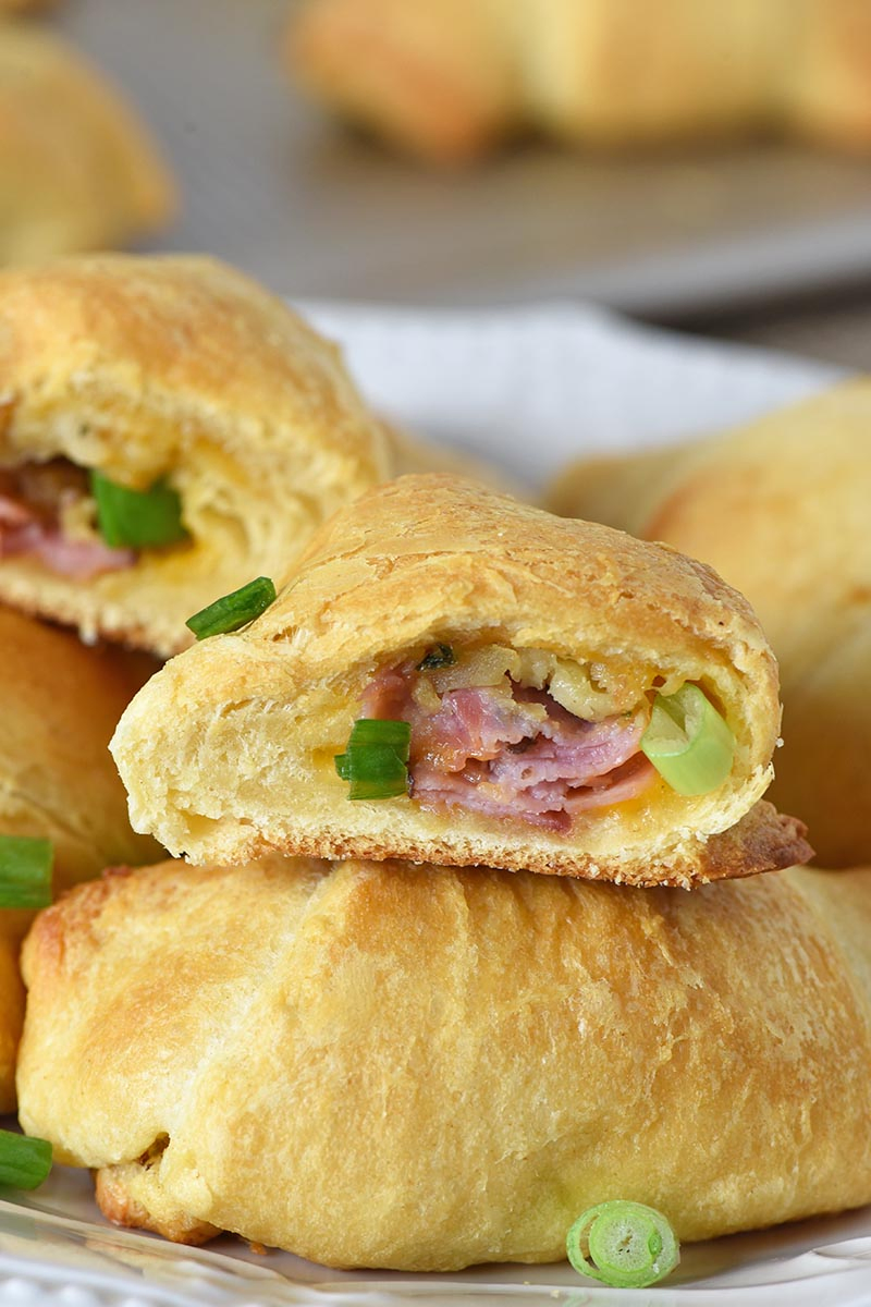 crescent rolls with leftover ham, stuffing, and cheese baked inside, stacked on a white plate