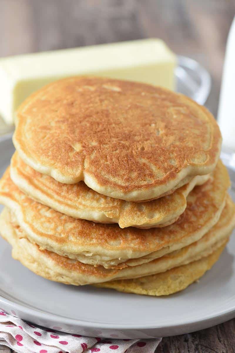 stack of butterbeer pancakes on gray plate with butter and milk