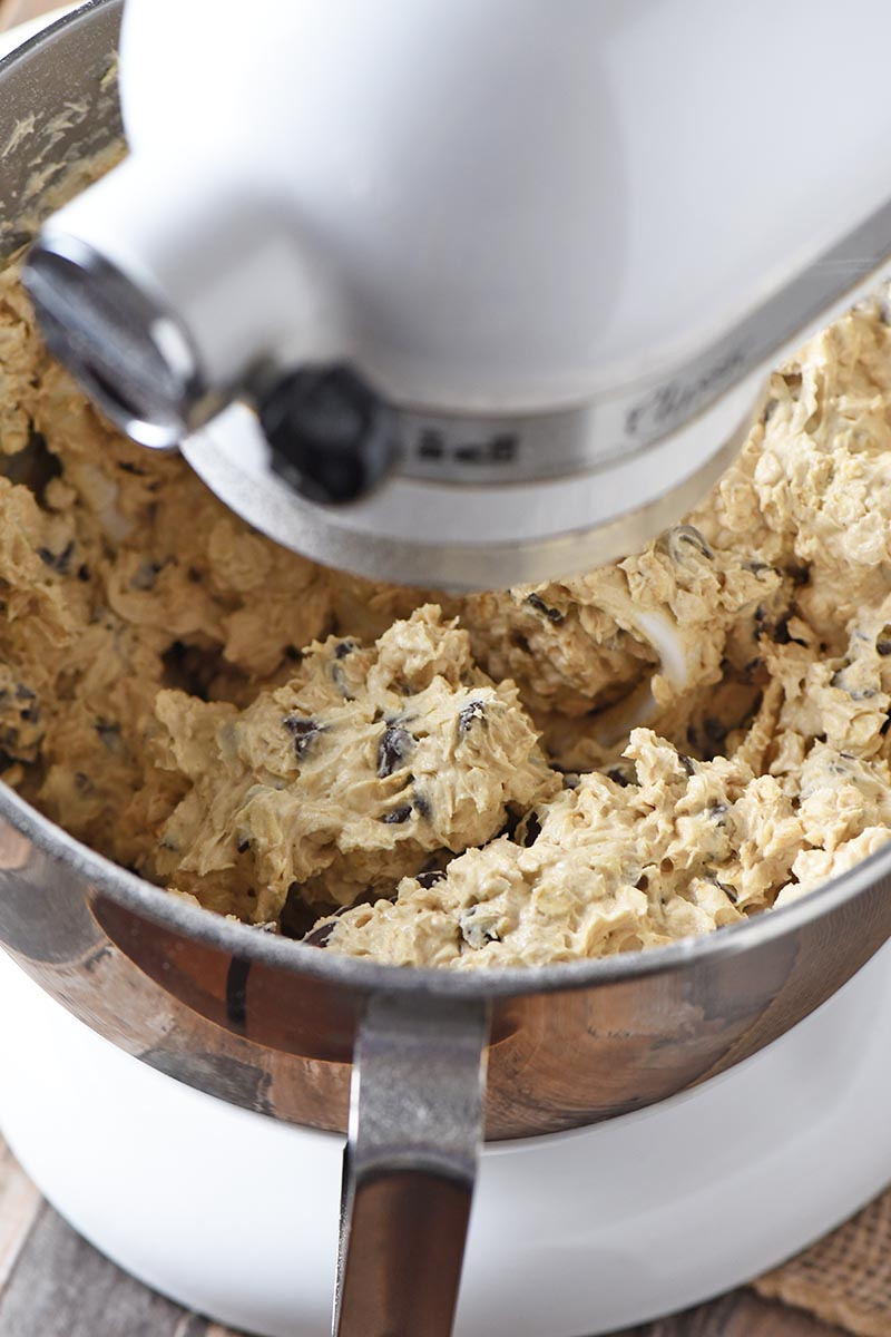 mixing up oatmeal chocolate chip cookie dough with rolled oats in white KitchenAid mixer