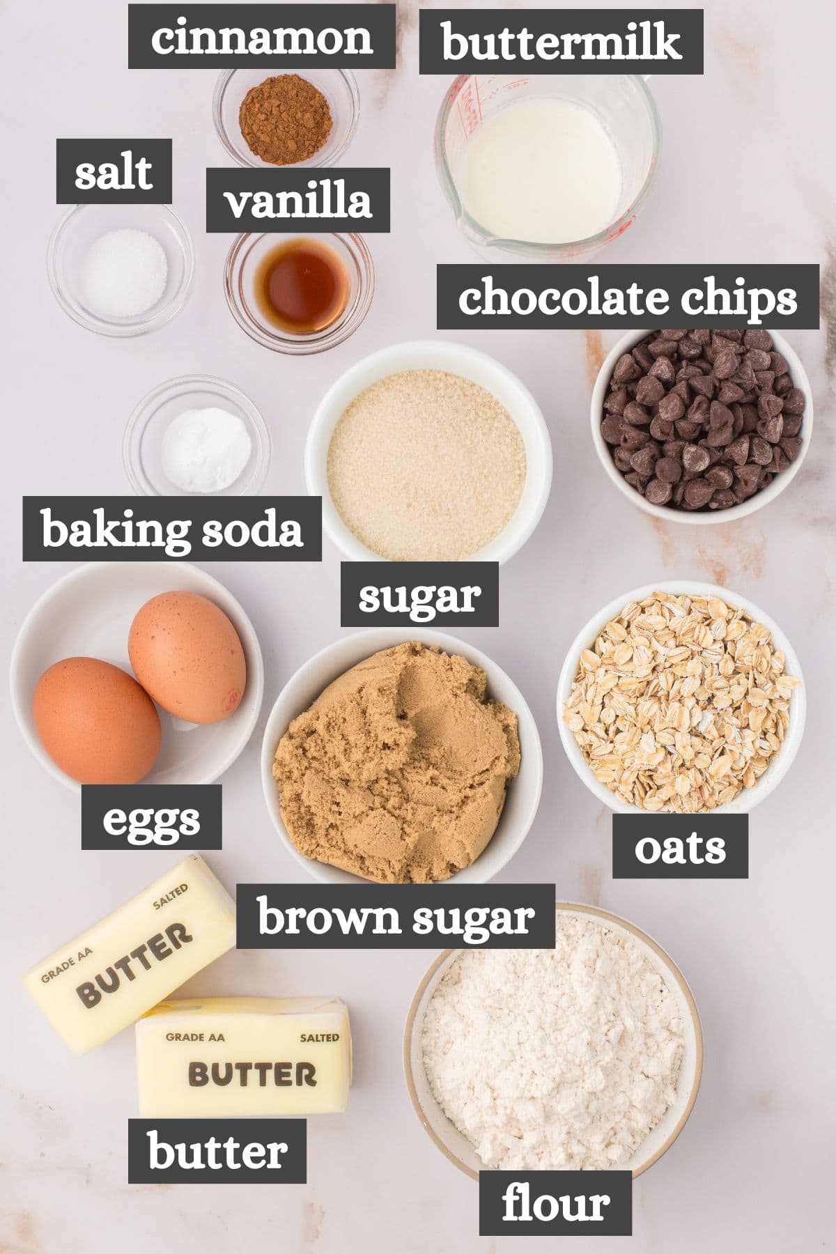 oatmeal chocolate chip cookies ingredients lined out on a white marbled countertop