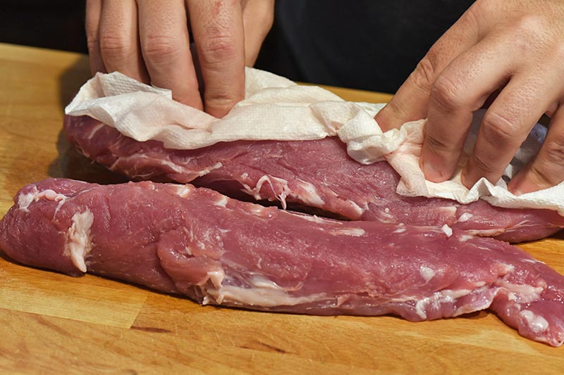 patting pork tenderloin dry with a paper towel