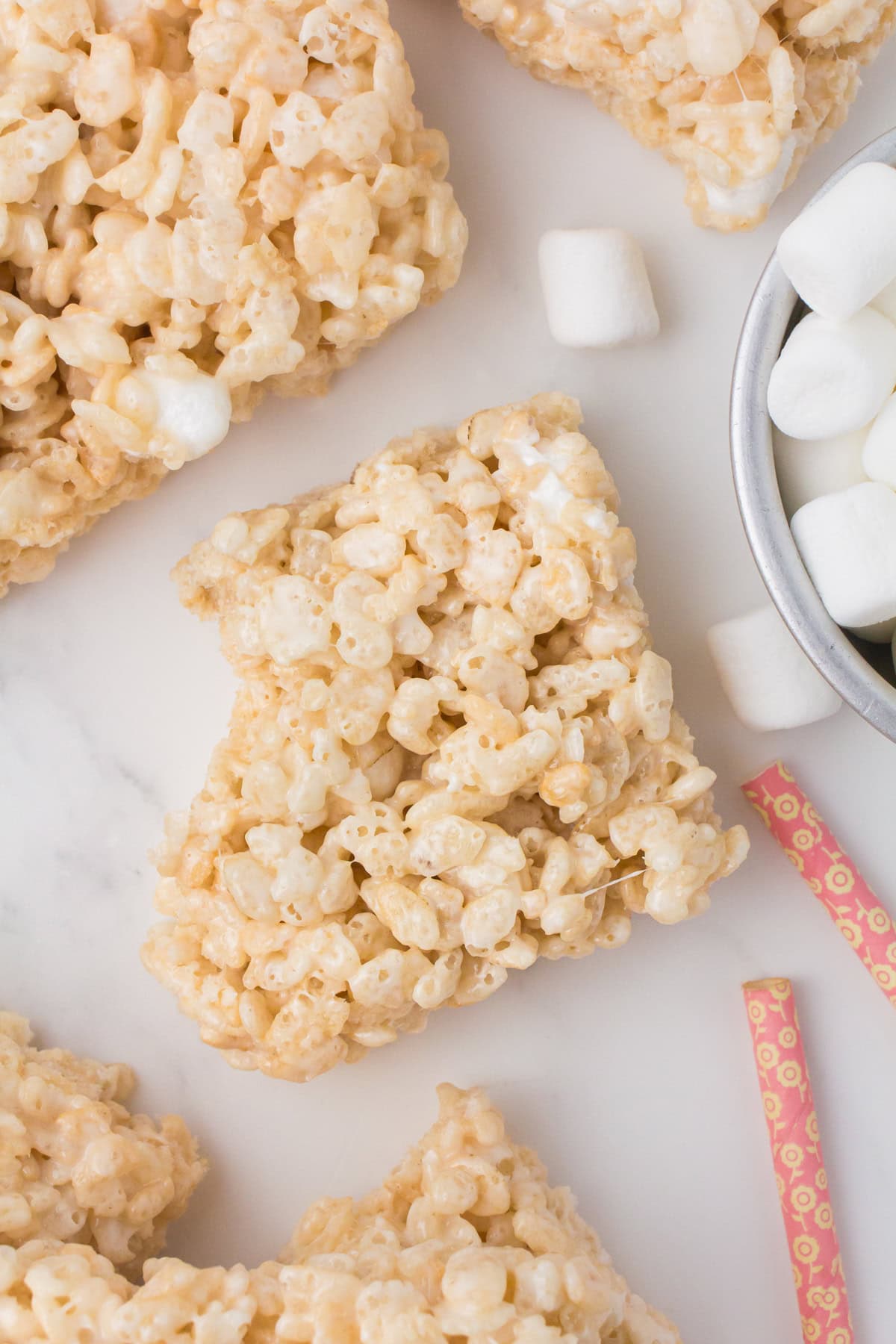 overhead shot showing a rice Krispie square with a bite taken out on a white countertop