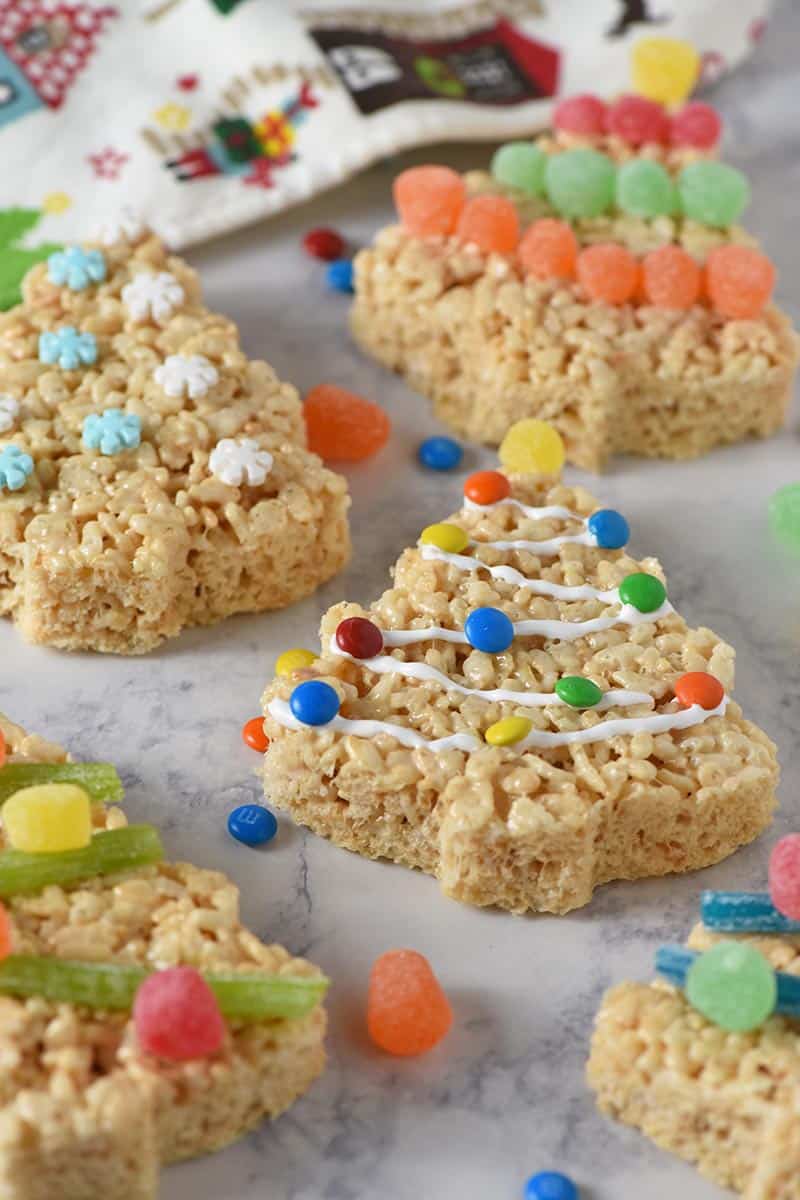 Rice Krispie Christmas trees decorated with marshmallow fluff and colorful candies