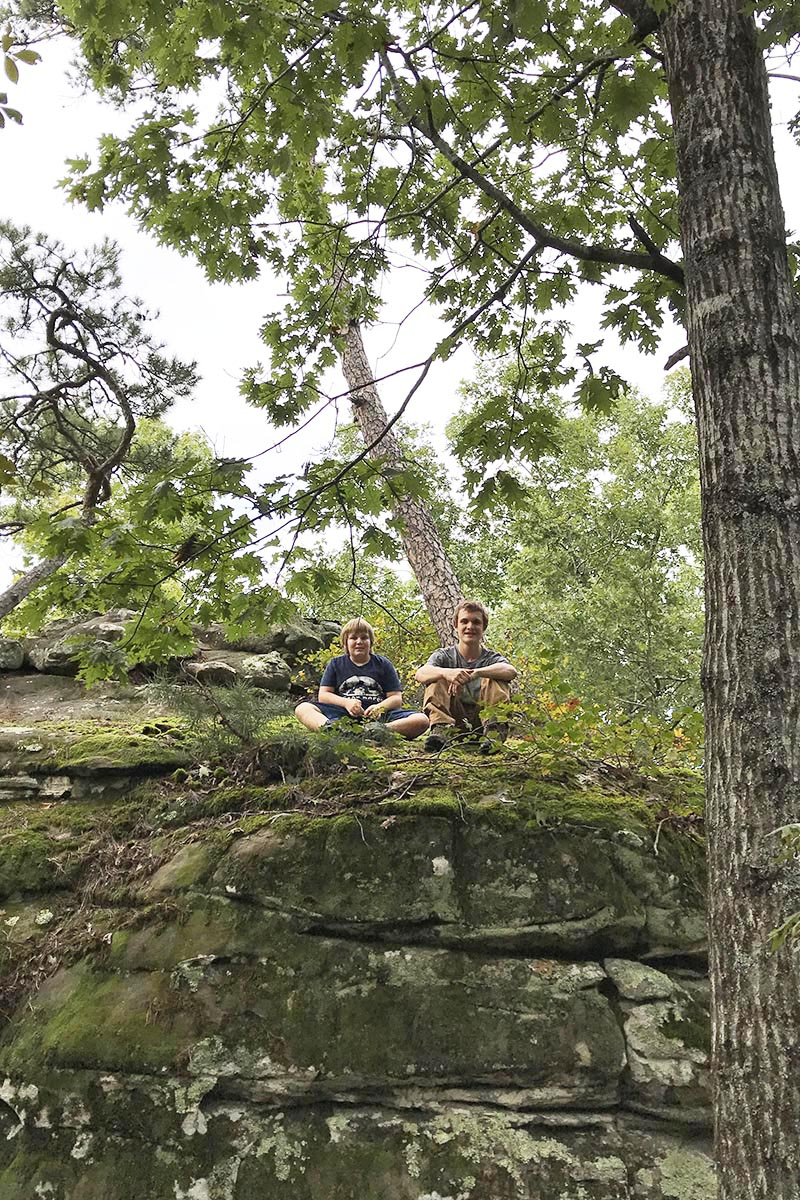 boys sitting on boulder along Bear Cave Trail in Petit Jean State Park, Arkansas