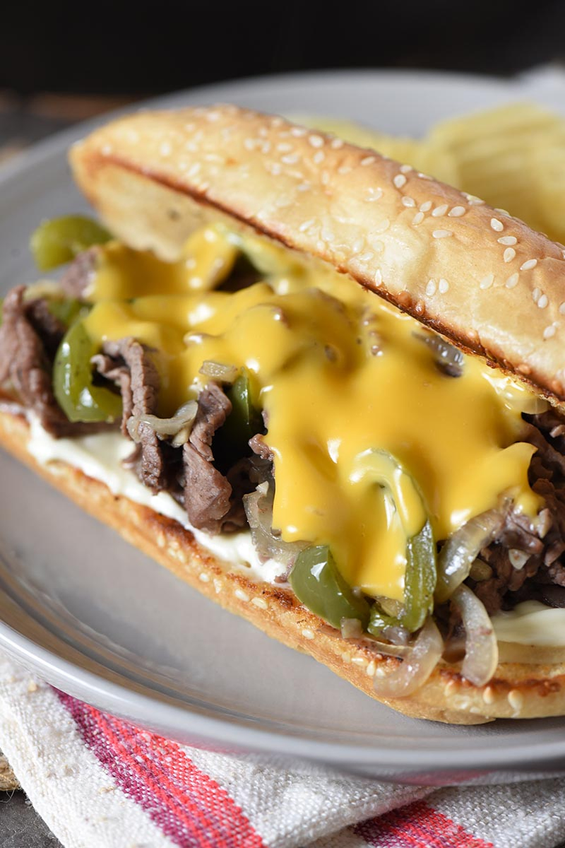 Philly cheese steak sandwich with Cheez Whiz on gray plate