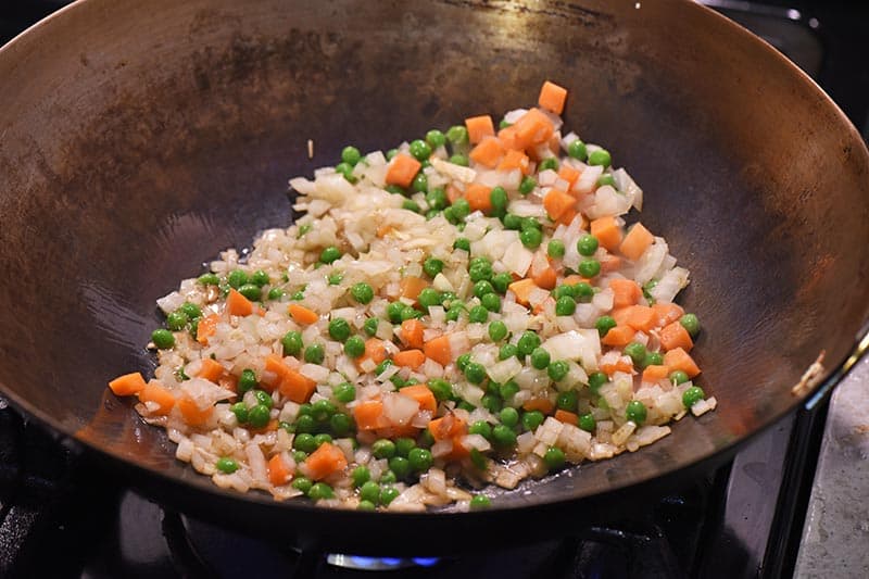 stir frying vegetables into hot sesame oil in large wok