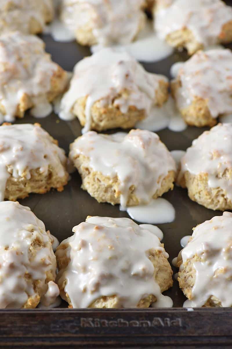 cinnamon biscuits brushed with icing on baking sheet