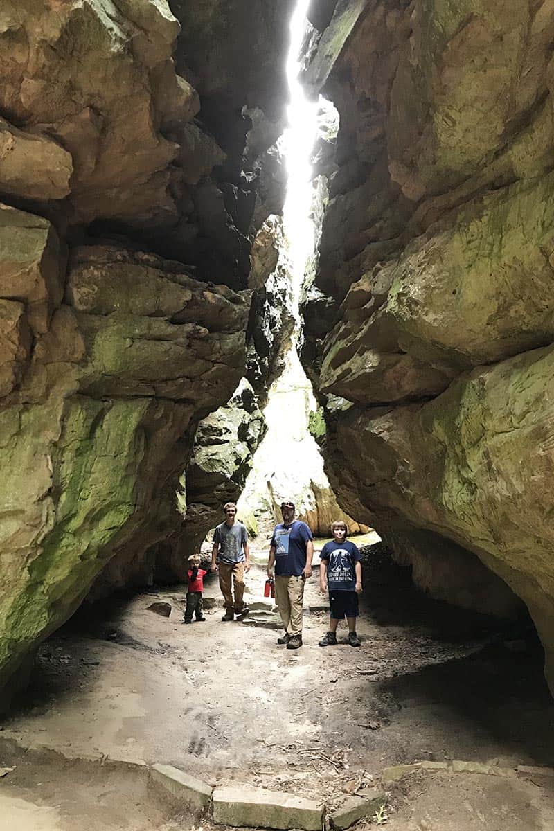 Family standing in Eye of the Needle on Bear Cave Trail in Petit Jean State Park in Arkansas