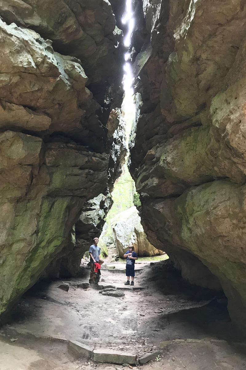 boys looking up through Eye of the Needle crevice in Petit Jean State Park