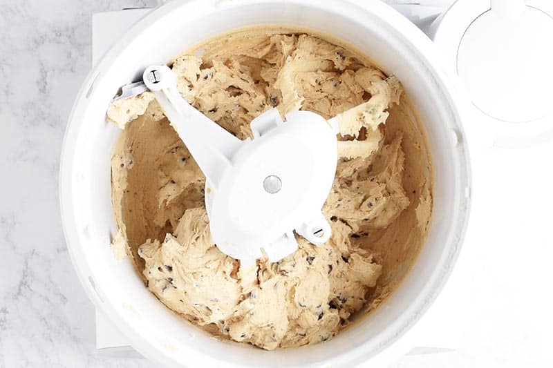 Mixing chocolate chip cookie dough with large white mixer