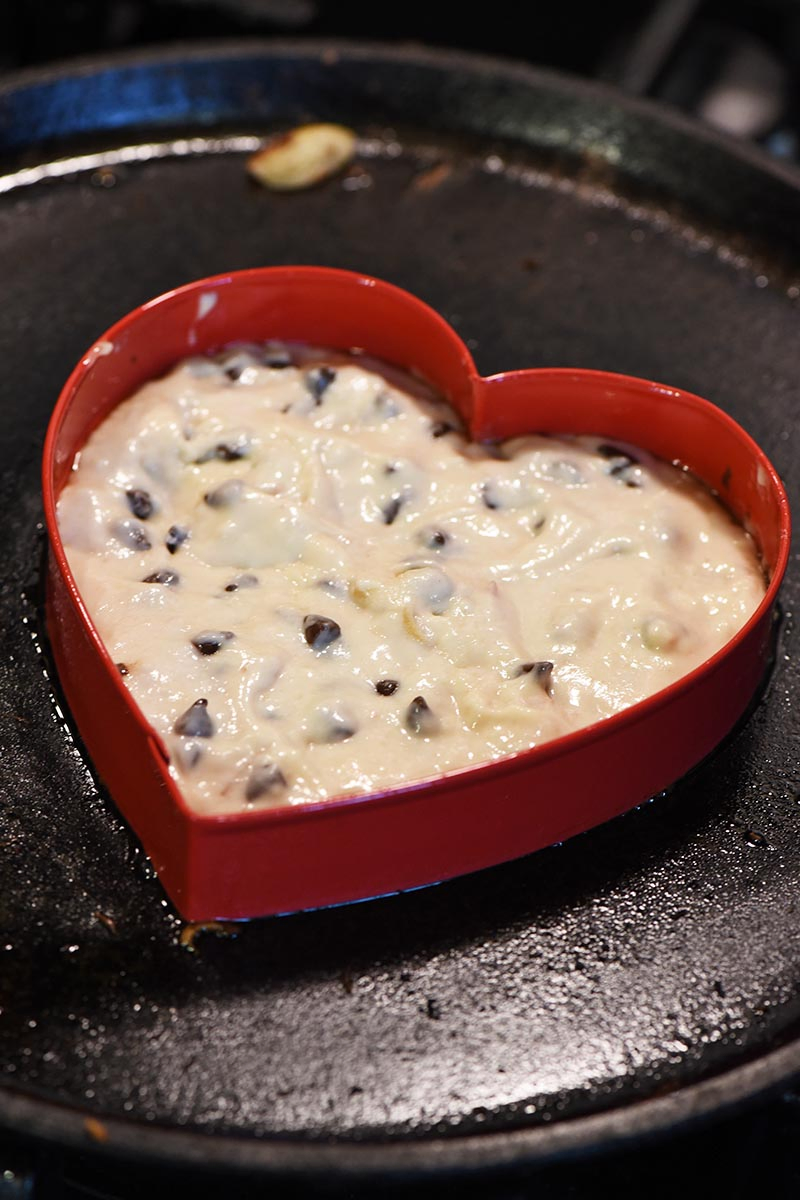 making heart pancakes recipe with heart shaped cookie cutter on cast iron griddle