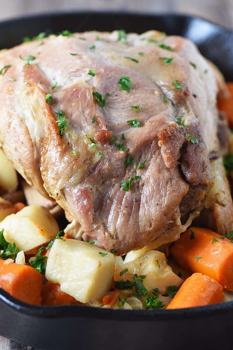 pork roast recipe with potatoes and carrots in cast iron skillet