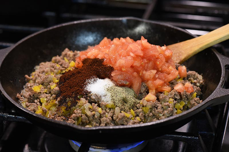 adding sauce ingredients to taco meat for taco stuffed peppers