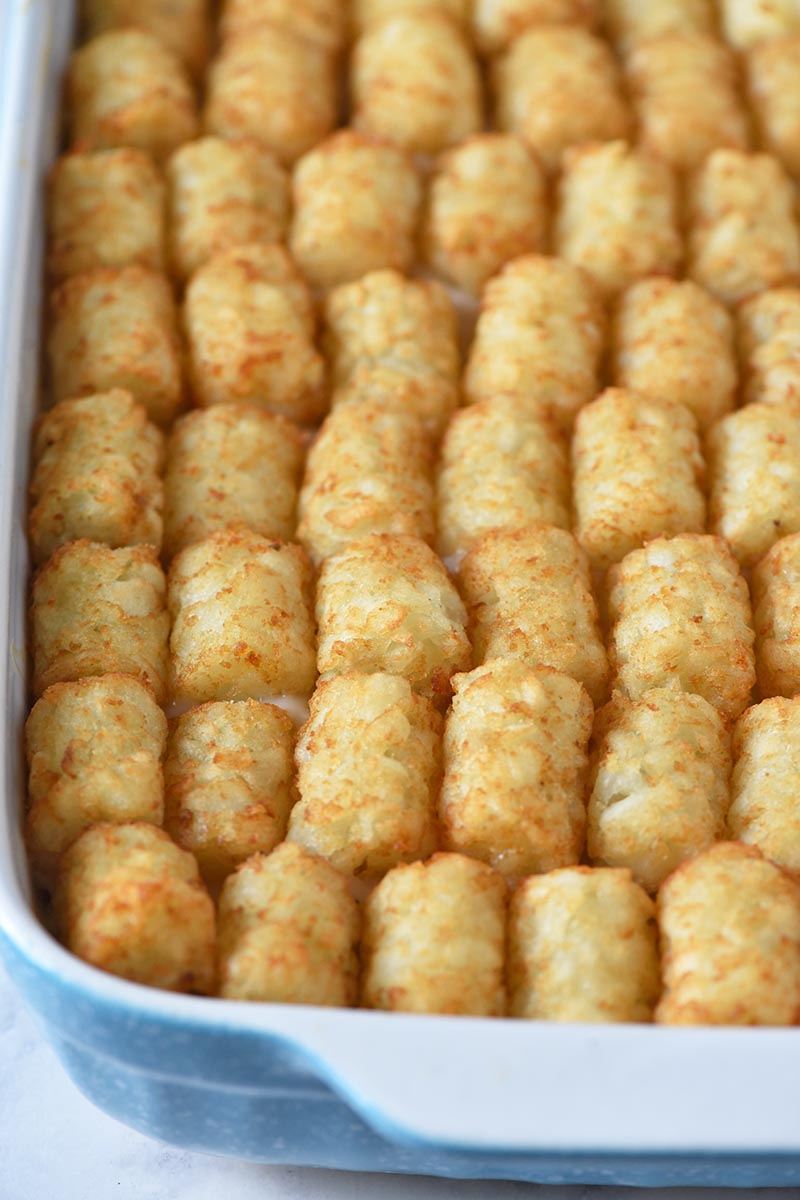 cooked tater tot hotdish in blue and white baking dish