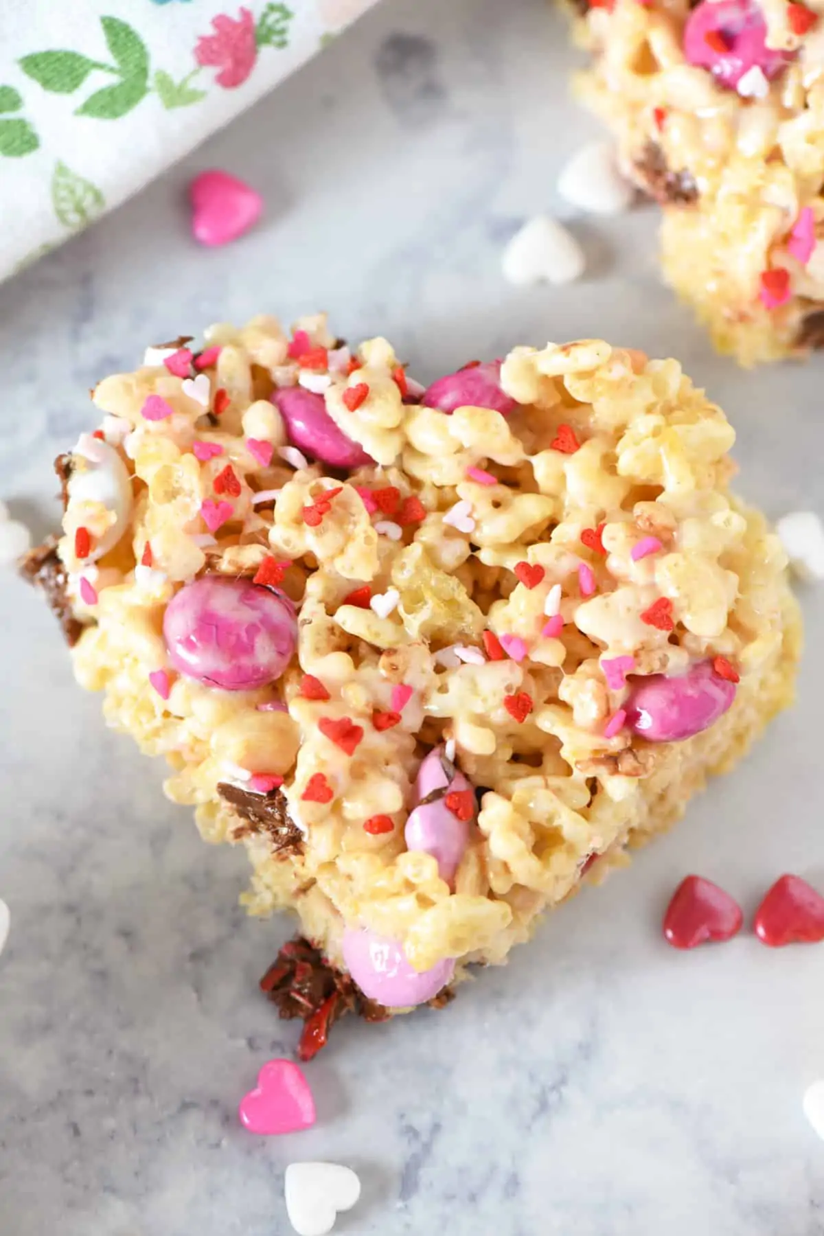 heart shaped Valentine Rice Krispie treats on white marble countertop with heart sprinkles