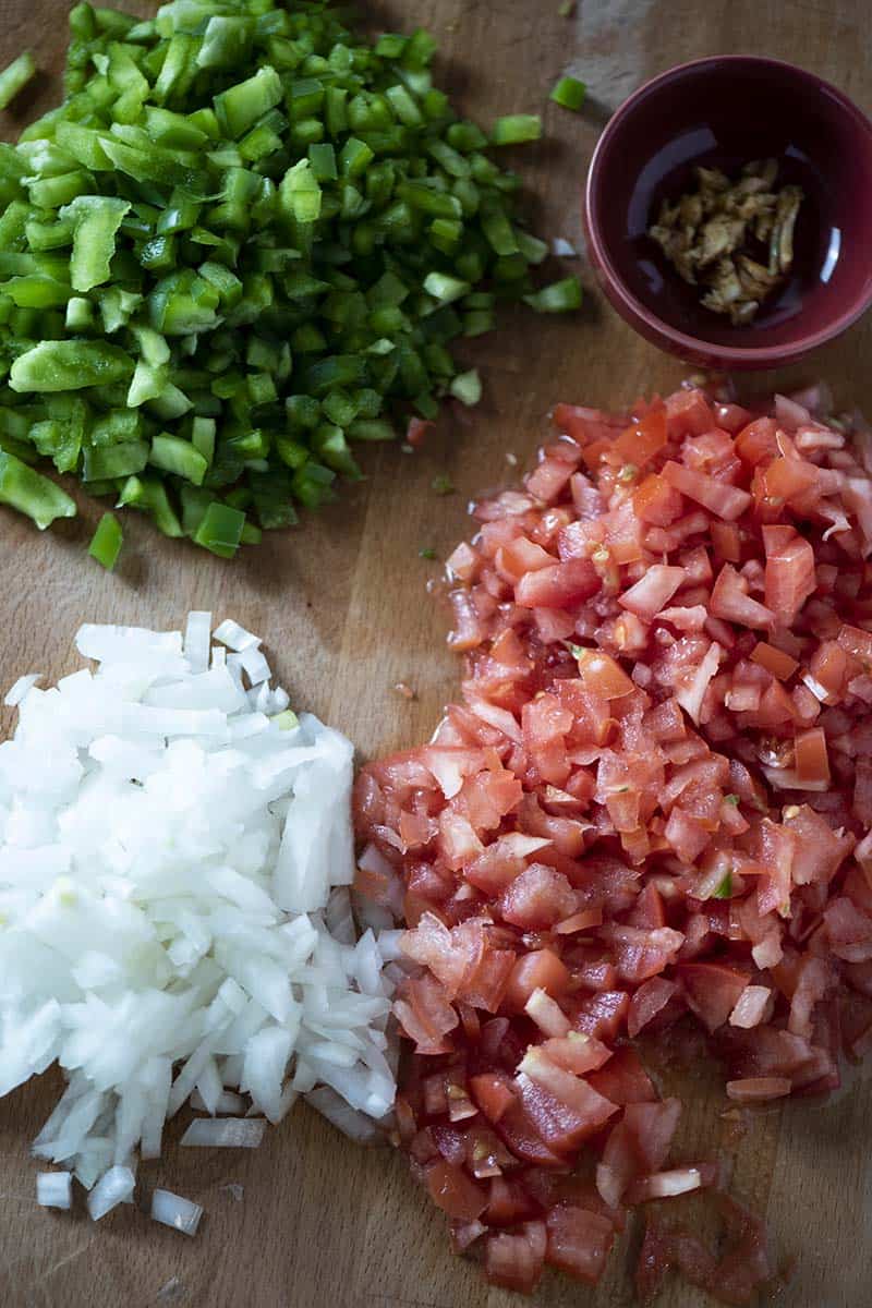 chopped bell peppers, garlic, minced onion, and diced tomatoes on cutting board, ingredients for easy chicken tortilla soup
