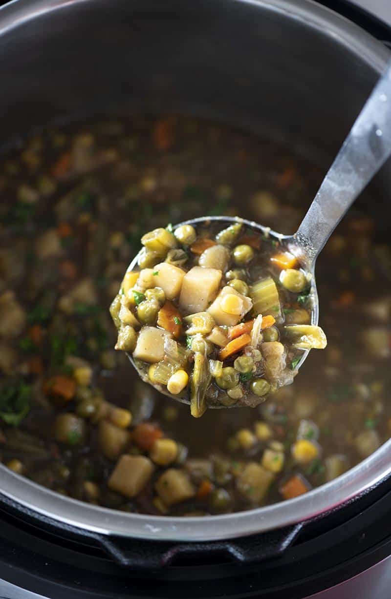 scoop of pressure cooker vegetable soup in ladle above Instant Pot