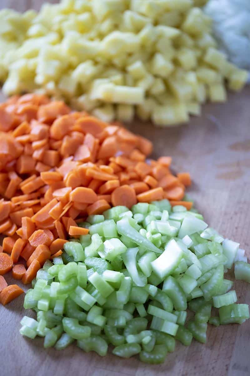chopped potatoes, onion, carrots, and celery for Instant Pot vegetable soup recipe, on cutting board