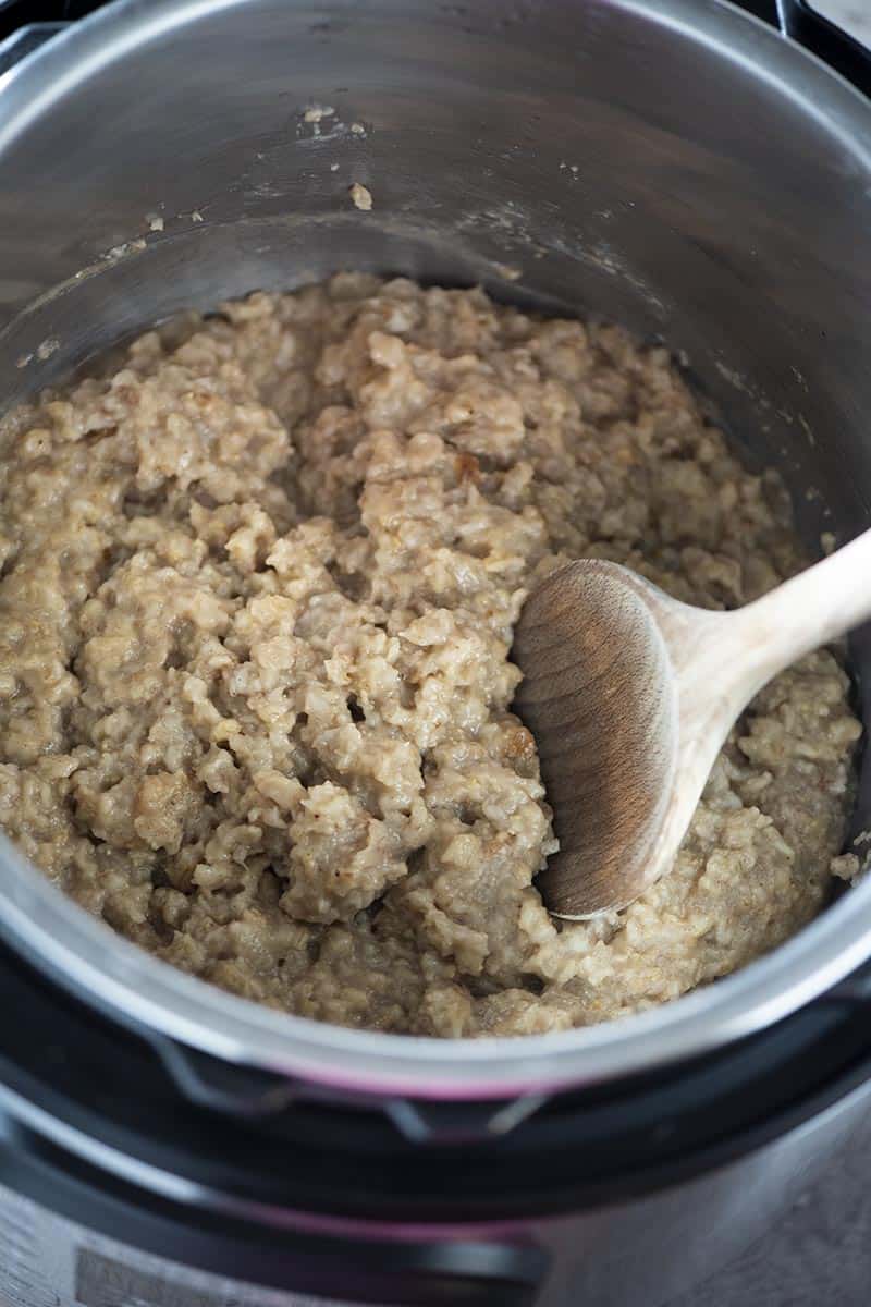 cooked maple and brown sugar Instant Pot oatmeal with a wooden spoon