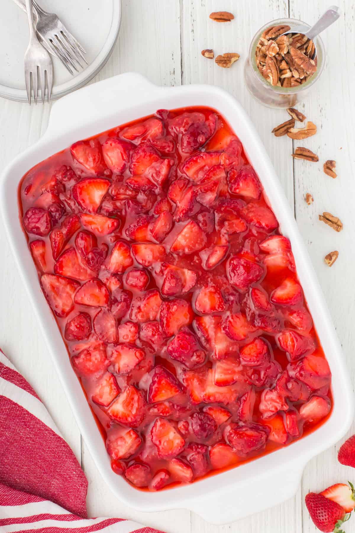 large white casserole pan full of no bake strawberry dessert on a white countertop