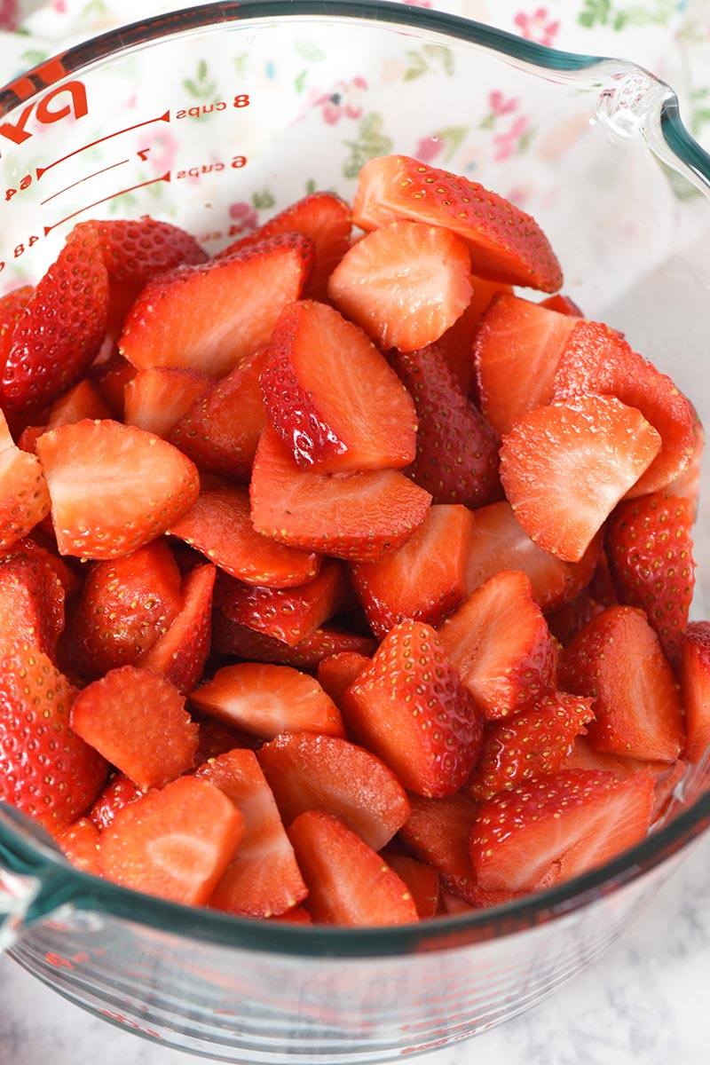 fresh strawberries sliced in a glass Pyrex measuring cup, ready for strawberry delight