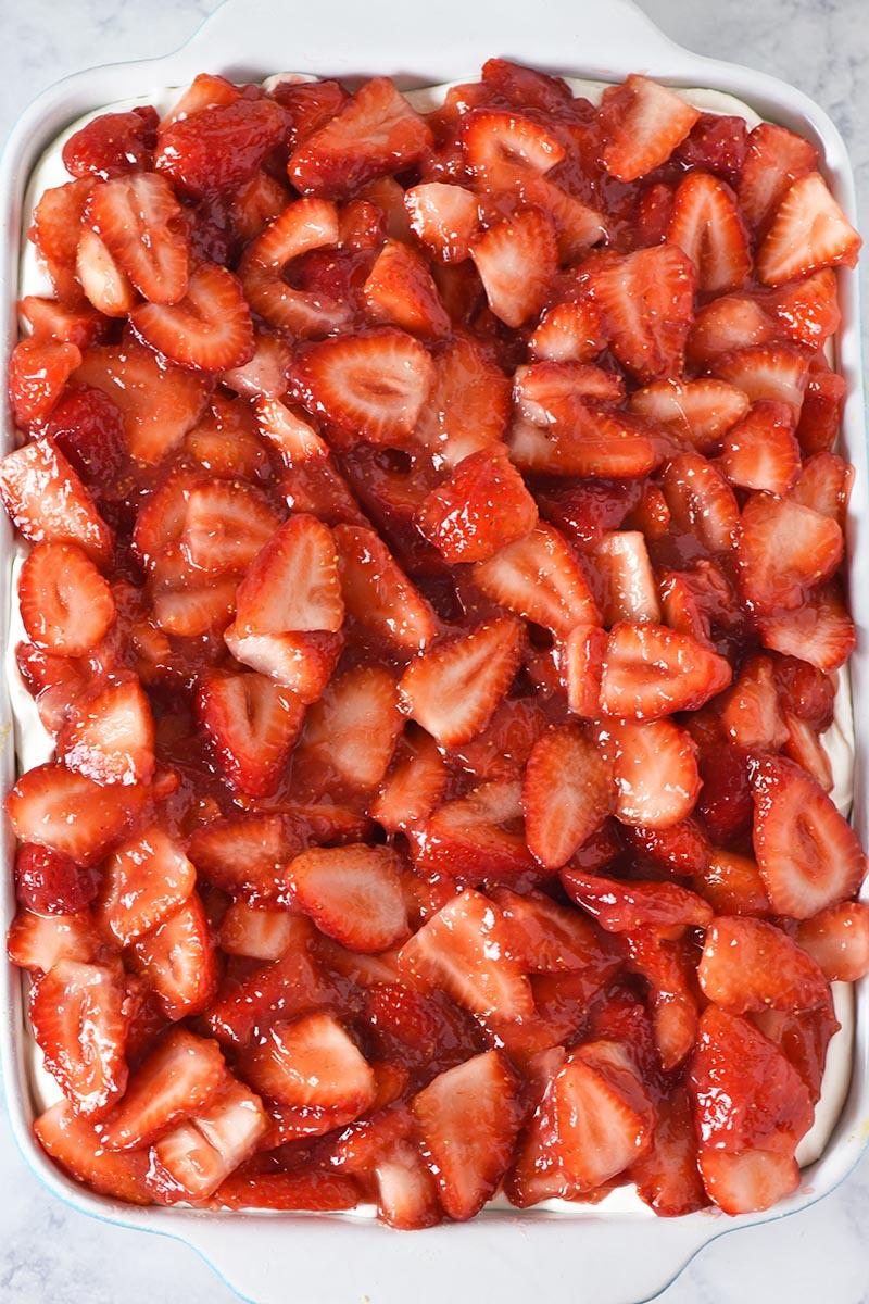 strawberry delight dessert in blue and white baking dish, made with fresh strawberries