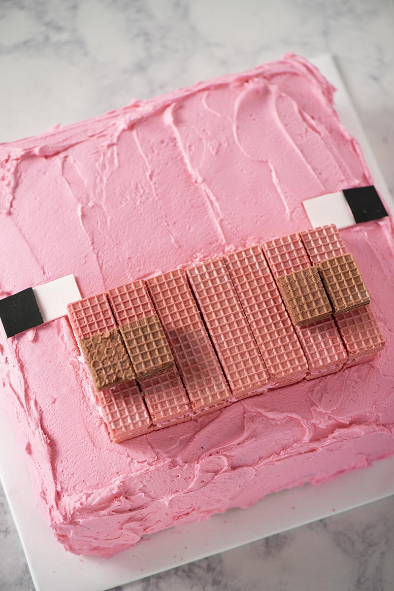 Pink pig Minecraft cake on white cake board