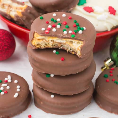 Ritz crackers with peanut butter dipped in chocolate stacked on white countertop