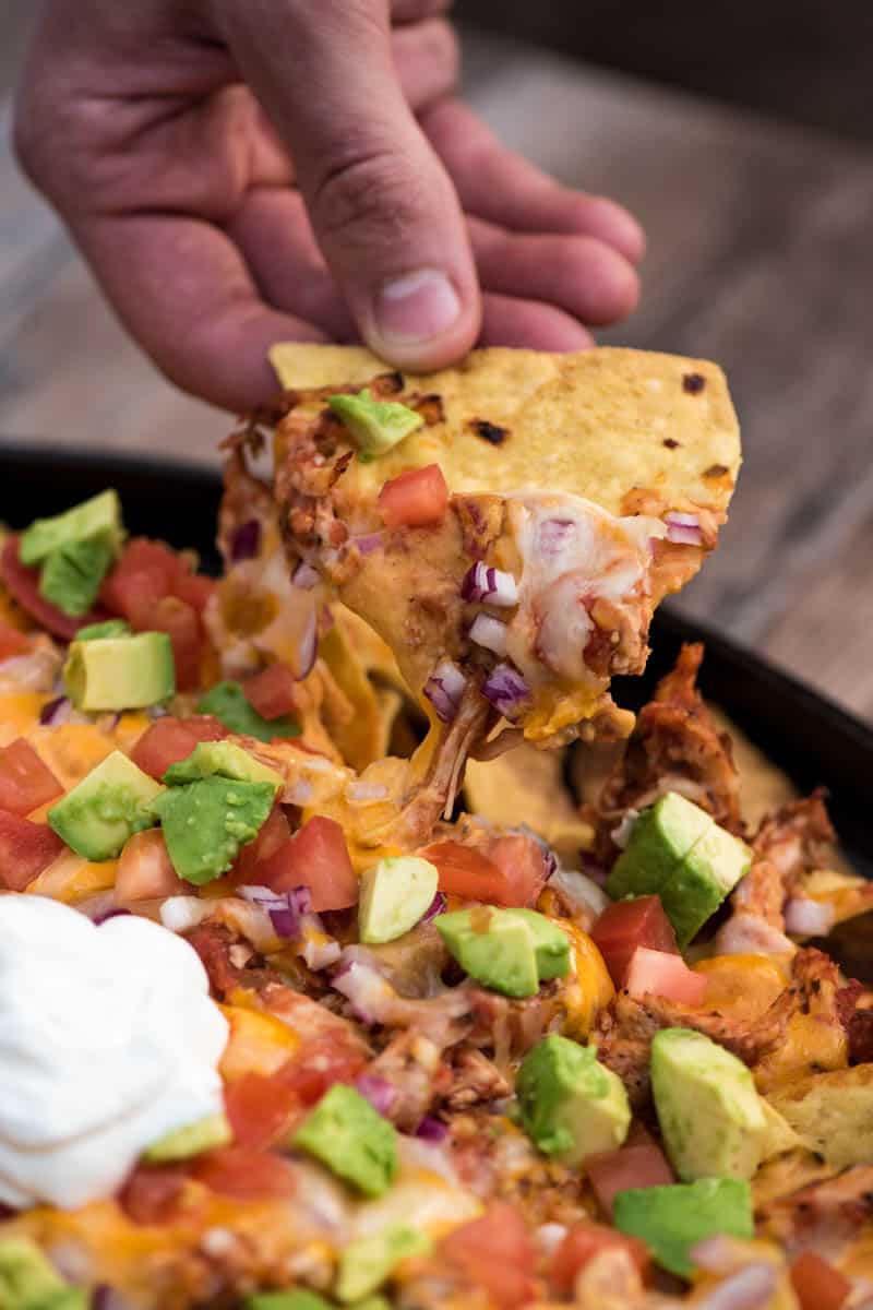 picking up campfire chicken nachos with melted cheese and all the toppings