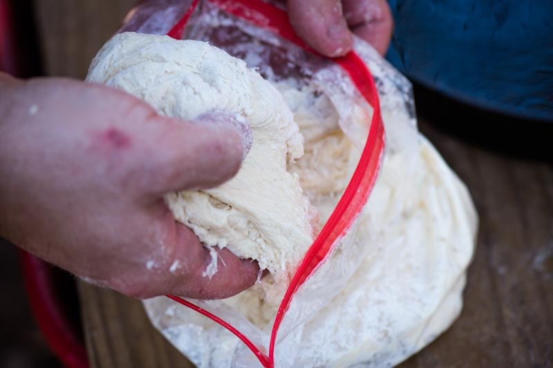 pulling pizza dough out of Ziploc bag