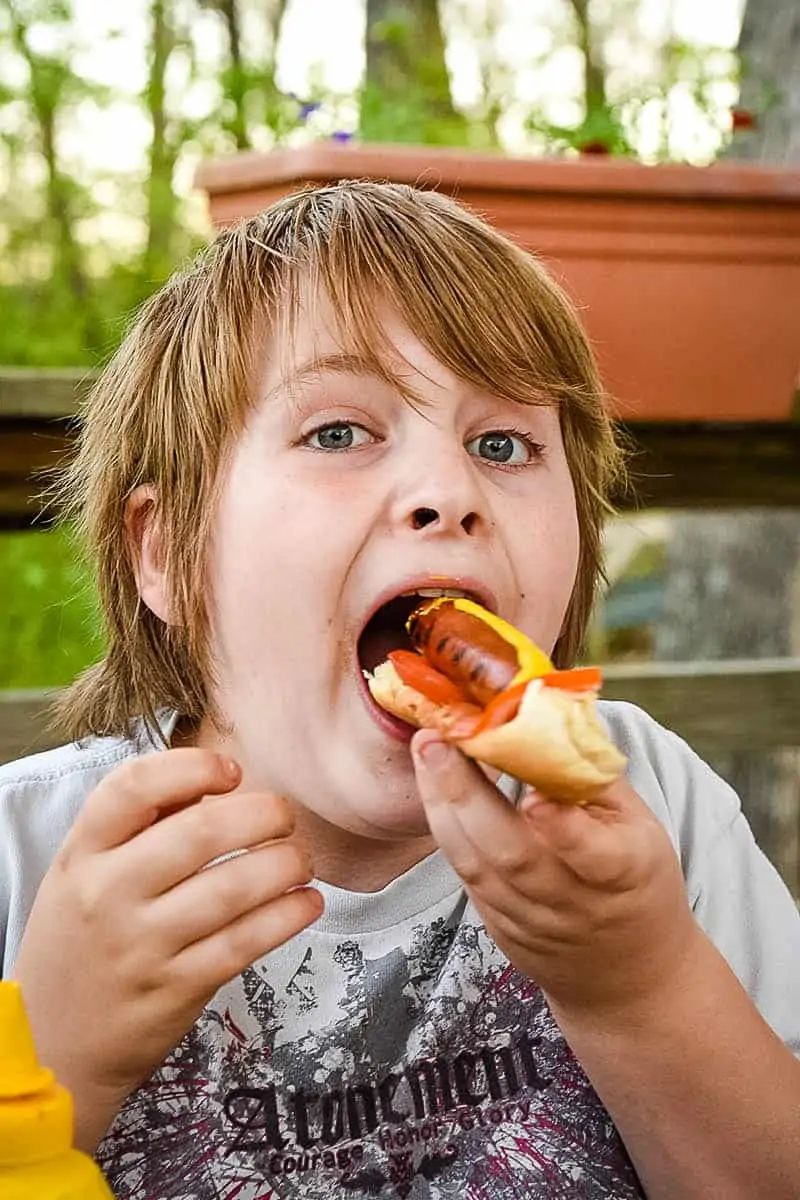 boy eating a Chicago style hot dog